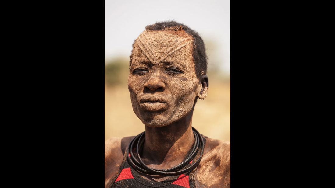 A Mundari woman with the ritual facial scarring, typical of the Mundari tribe, and covered in ash, a purported natural antiseptic which also protects the skin from insects.
