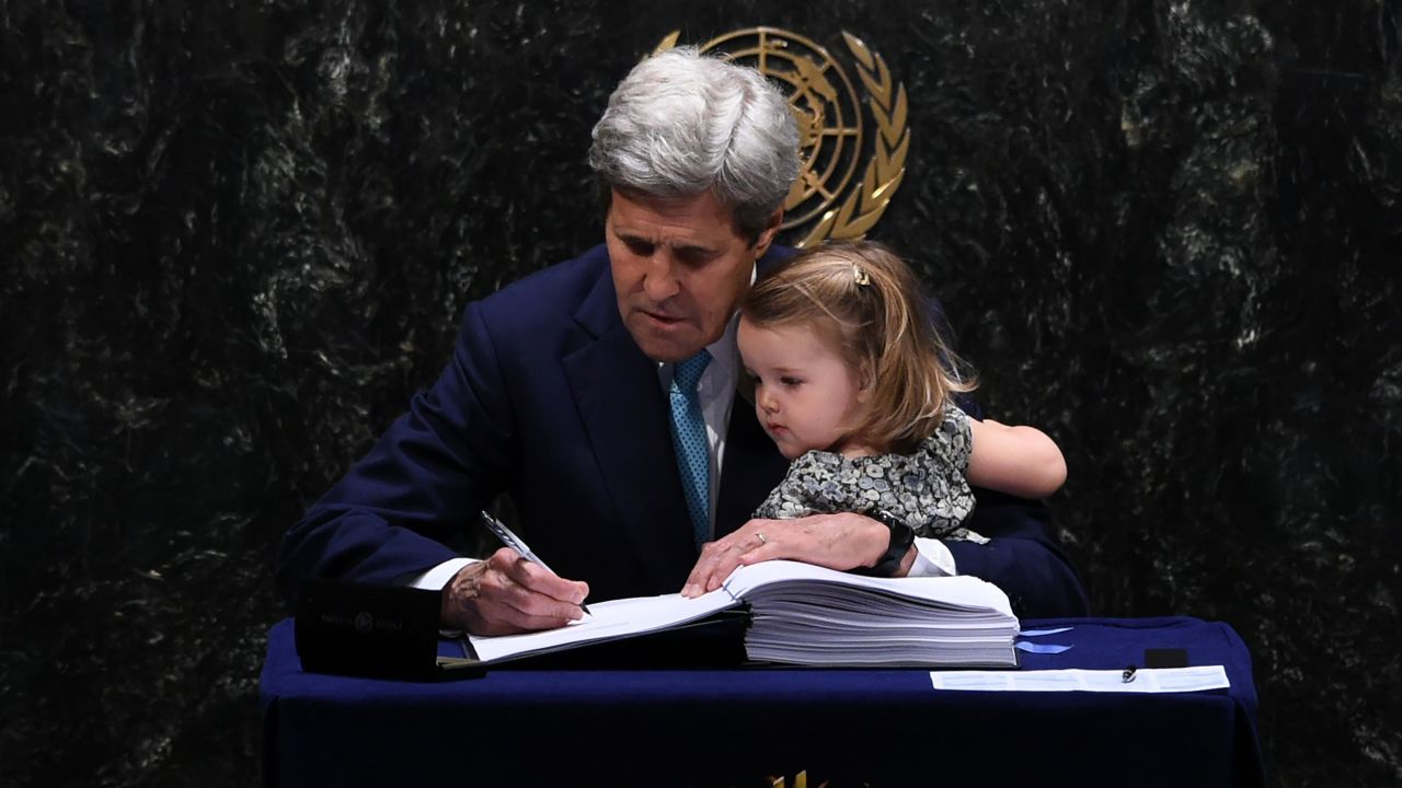 Secretary of State John Kerry signs the Paris Agreement with granddaughter Isabelle Dobbs-Higginson.