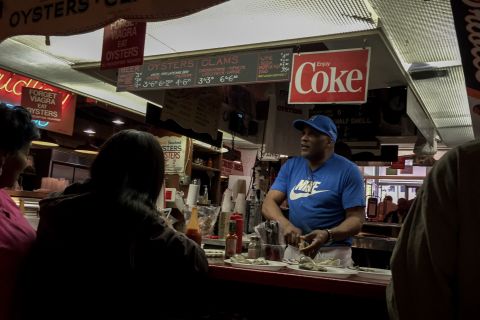 A man serves raw oysters in Baltimore's famous Lexington Market. In recent years the city has invested heavily in  tourism, hoping to attract external dollars to the city.