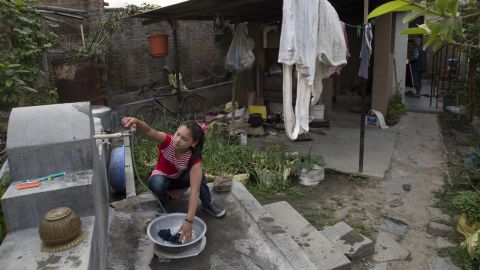 Maya washes her clothes outside the home of a family that has given her a new life in Kathmandu.
