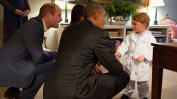 In this handout provided by The White House, President Barack Obama, Prince William, Duke of Cambridge and First Lady Michelle Obama talks with Prince George at Kensington Palace on April 22, 2016 in London, England.
