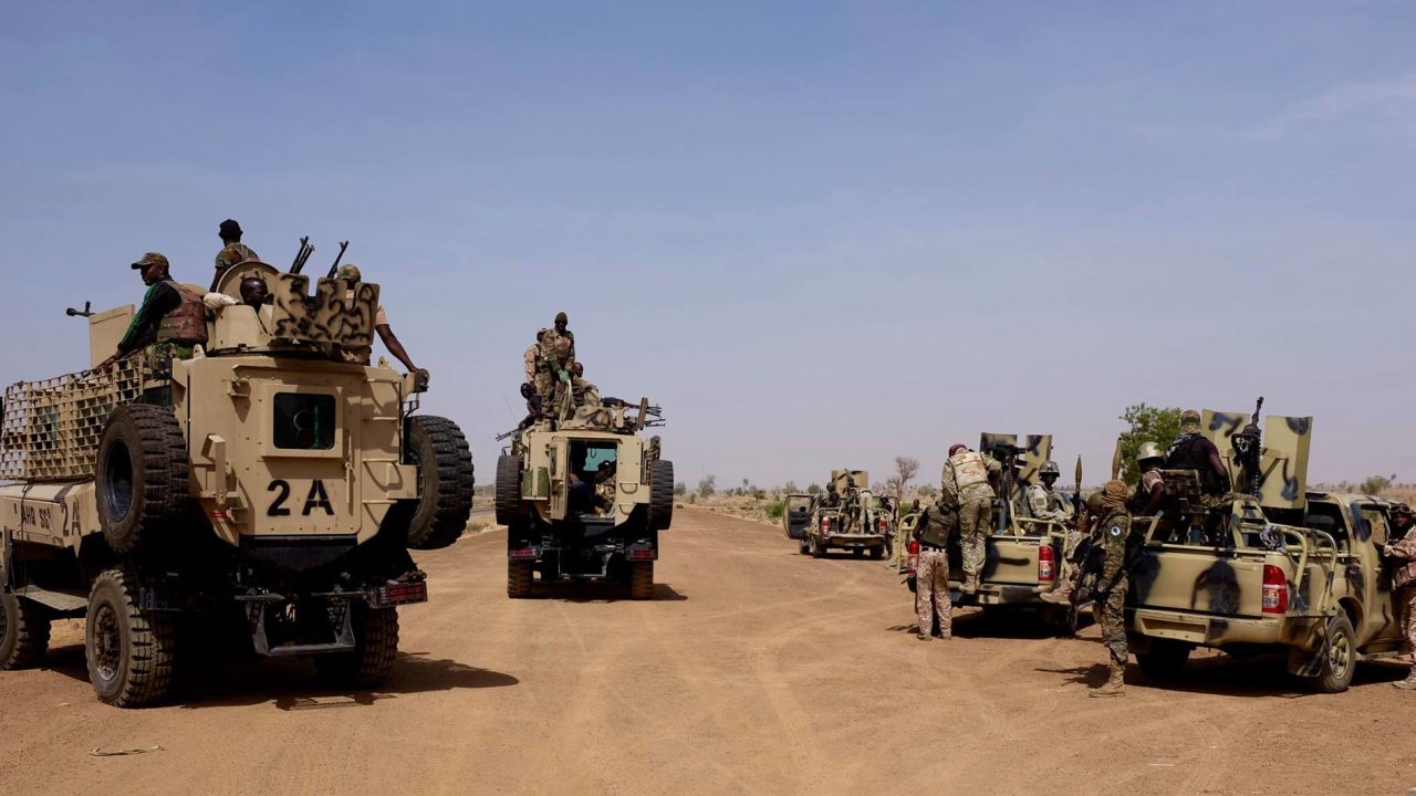 A heavily armored convoy of Nigerian Army personnel travel down the dusty road leading to the Sambisa Forest earlier this year. 