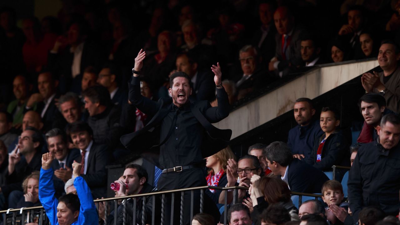 Diego Simeone enocourages the crowd from the stand after being sent off during Atletico Madrid's match with Malaga.
