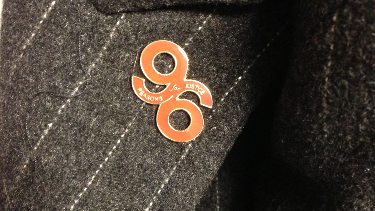 "96 reasons for justice" -- A lapel pin commemorates the lives lost, while calling for an inquiry. 