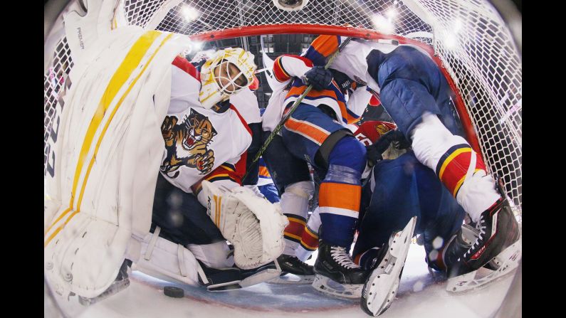 Players crowd the crease of Florida goalie Roberto Luongo during an NHL playoff game in New York on Wednesday, April 20. The New York Islanders eliminated Florida in six games.