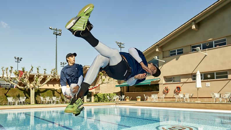 Tennis stars Mike Bryan, left, and his twin brother, Bob, dive into a swimming pool after winning the doubles final at the Barcelona Open on Sunday, April 24.