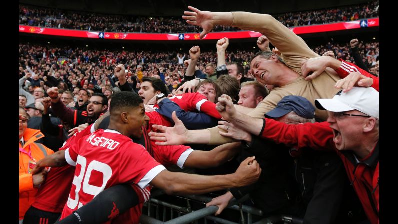 Manchester United supporters embrace some of the players after Anthony Martial scored the match-winning goal in the FA Cup semifinals on Saturday, April 23. Martial <a href="index.php?page=&url=http%3A%2F%2Fwww.cnn.com%2F2016%2F04%2F23%2Ffootball%2Ffa-cup-anthony-martial-manchester-united-everton%2F" target="_blank">scored in the 93rd minute</a> to give United a 2-1 victory over Everton in London. 