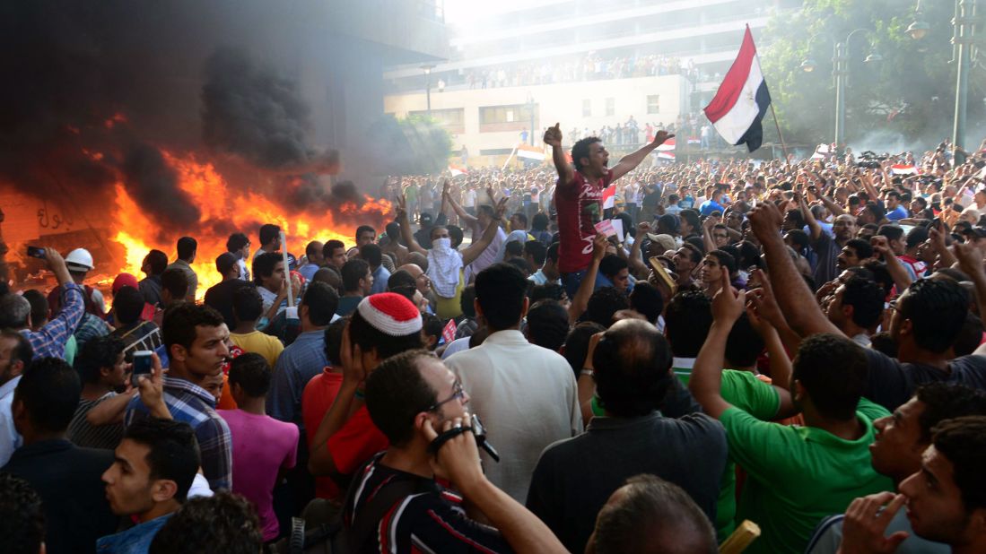 Morsy opponents chant slogans as fire rages at the Muslim Brotherhood headquarters in Alexandria in June 2013. Months earlier, Morsy granted himself unprecedented executive powers, preventing any court from overturning his decisions. He refused to bow to an ultimatum, issued by Egypt's military leaders, to find a solution to violence in the country or leave his post.