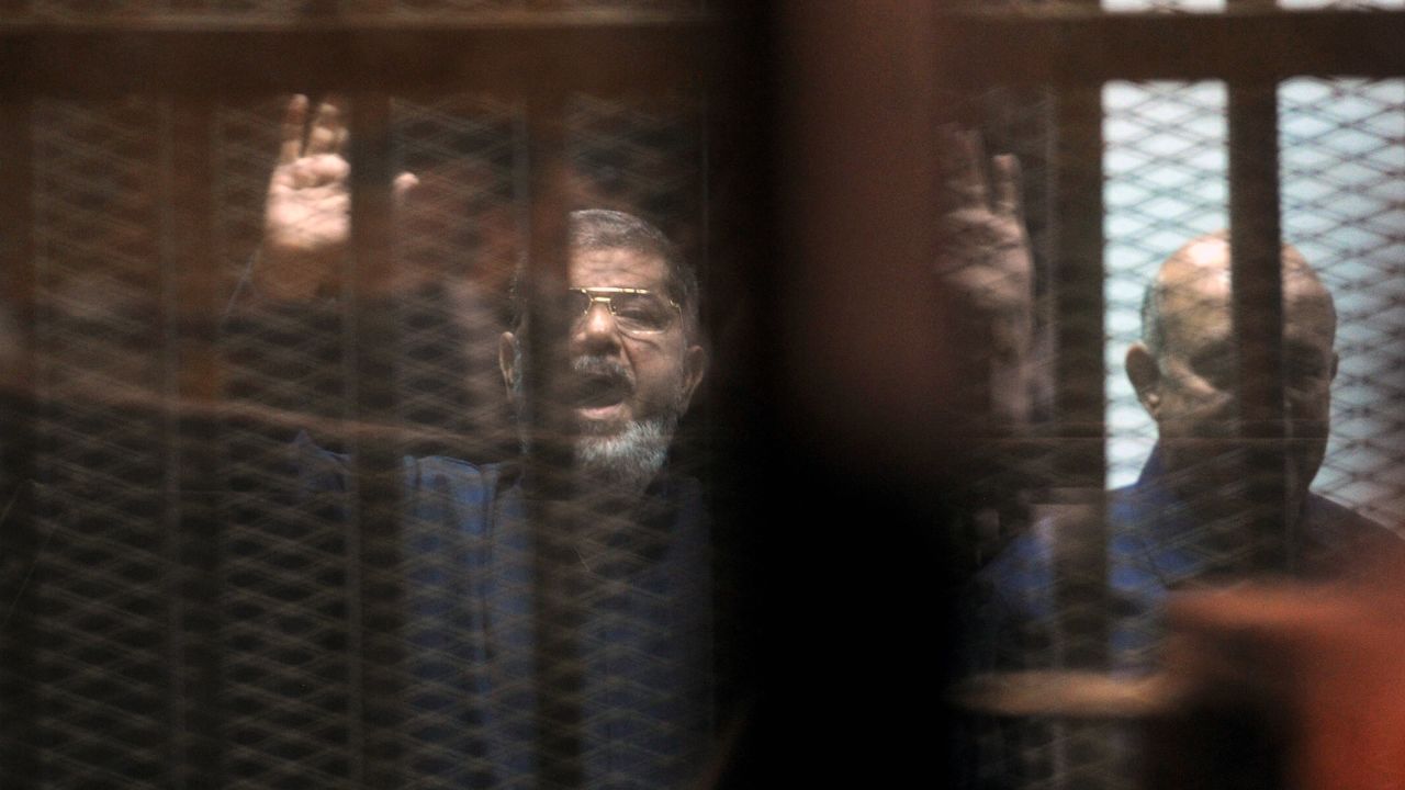 Morsy, left, and Muslim Brotherhood leader Mohamed Badie stand behind bars in June 2015. Morsy was sentenced to death for his role in a 2011 prison break. He and 16 other Muslim Brotherhood leaders were also given a life sentence for espionage. A life term in Egypt means 25 years.