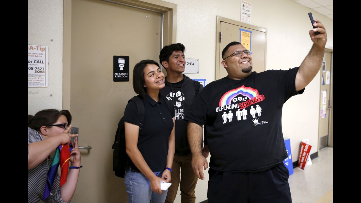 People pose in front of the gender-neutral restroom they lobbied for in the Los Angeles school district on Tuesday, April 19.