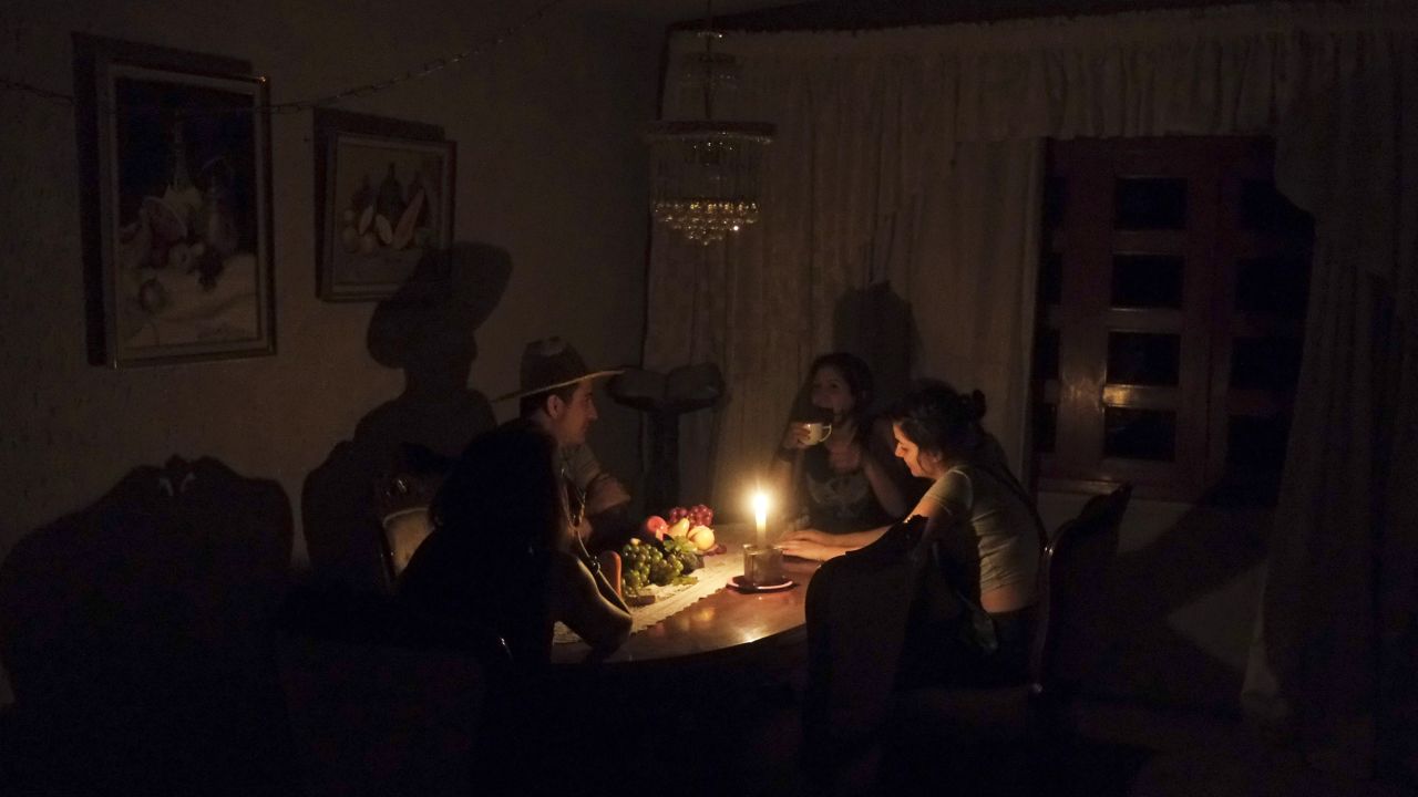 A family sit at a candle lit table in the state of Barinas, Venezuela on April 25.