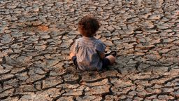 A child sits at an area affected by a drought on Earth Day in the southern outskirts of Tegucigalpa, Honduras.
