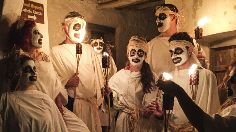 Locals celebrating the Greek god Dionysus parade through the streets of Naxos with torches.