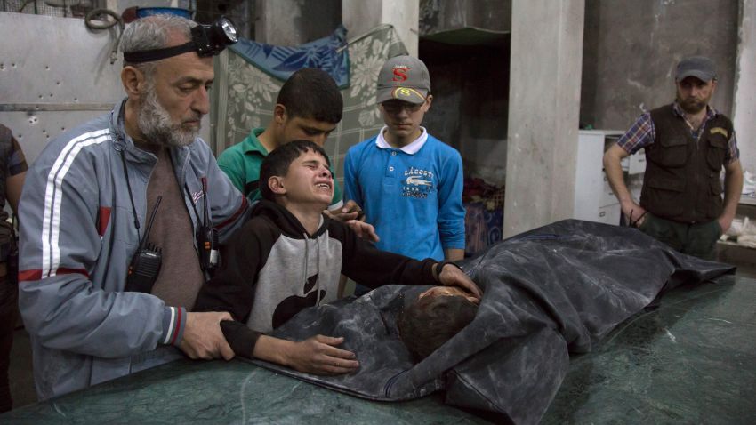 A Syrian boy is comforted as he cries next to the body of a relative who died in a reported airstrike on April 27, 2016 in the rebel-held neighbourhood of al-Soukour in the northern city of Aleppo.  / AFP / KARAM AL-MASRI        (Photo credit should read KARAM AL-MASRI/AFP/Getty Images)