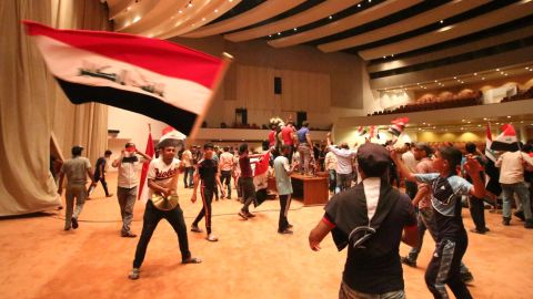 Iraqi protesters wave national flags inside Parliament after breaking into Baghdad's heavily fortified "Green Zone" on April 30, 2016. 