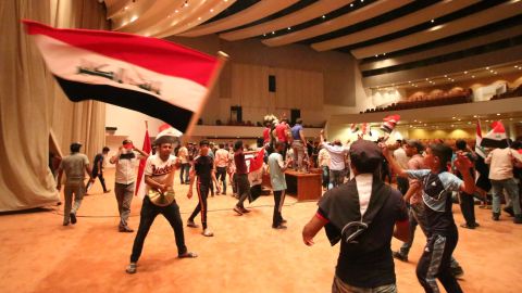 Iraqi protesters wave national flags inside Parliament after breaking into Baghdad's heavily fortified "Green Zone" on April 30, 2016.