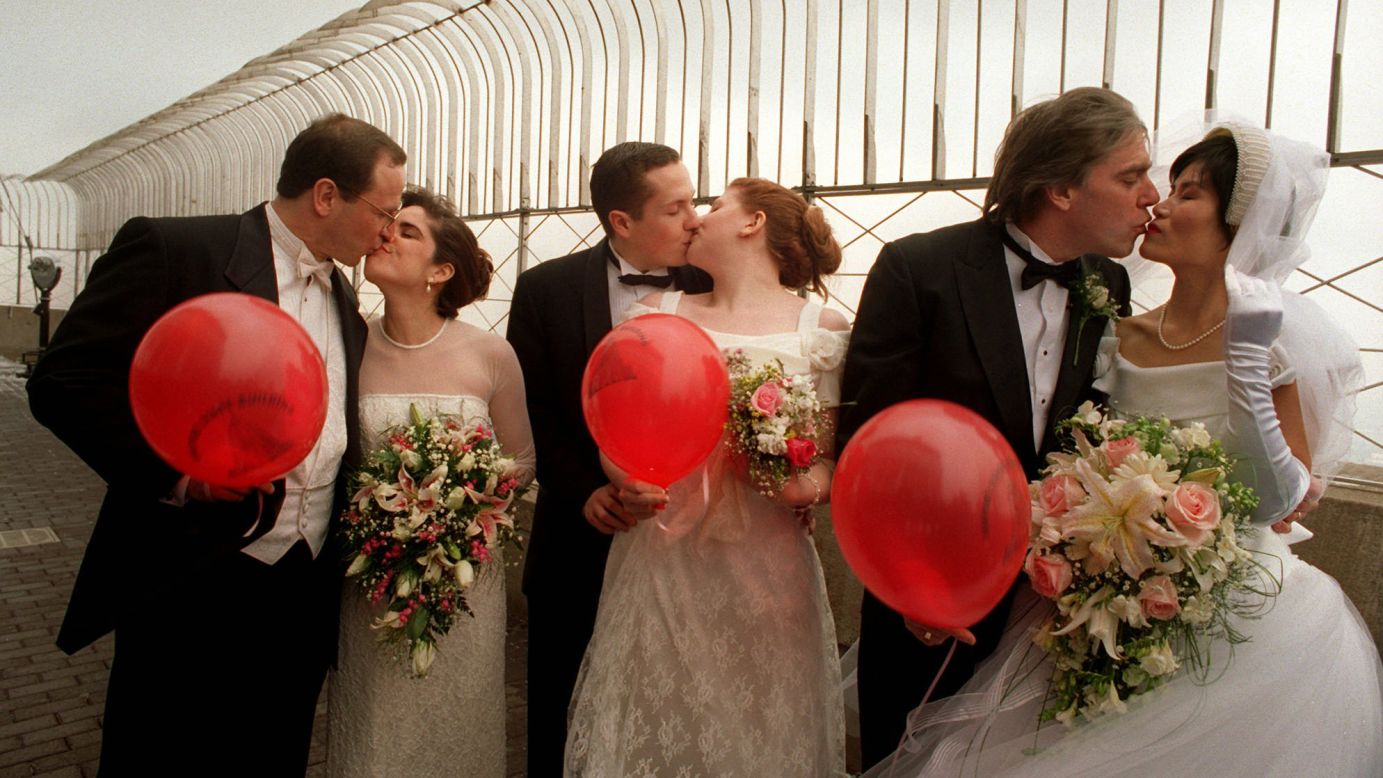 Couples kiss on the observation deck after participating in the Valentine's Day marriage marathon on February 14, 1996. Every year on Valentine's Day, couples who marry on the 80th floor become members of the Empire State Building Wedding Club. They receive free admission to the observatory each year on February 14 (their anniversary) thereafter.
