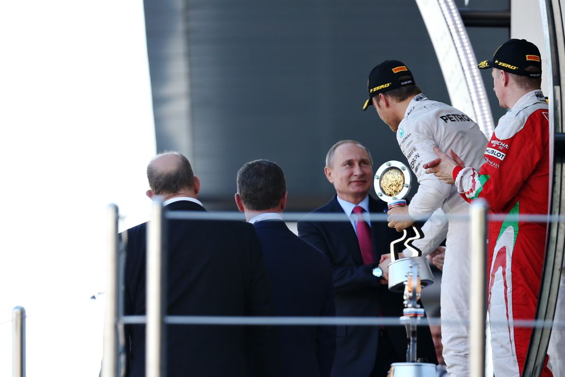 Rosberg is handed his winner's trophy by Russia president Vladimir Putin