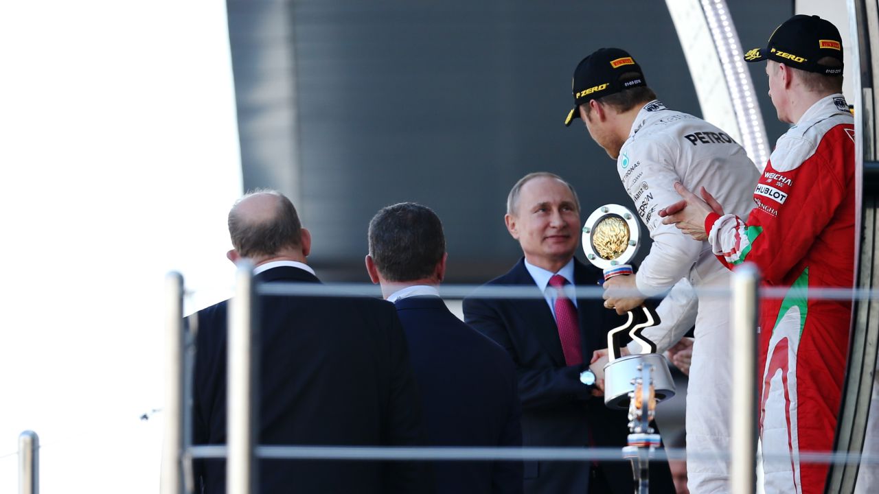 Rosberg is handed his winner's trophy by Russia president Vladimir Putin
