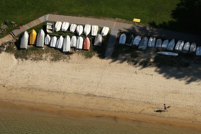 Rowing boats are lined up on the beach at Forty Baskets, a beach offering spectacular harbor views.