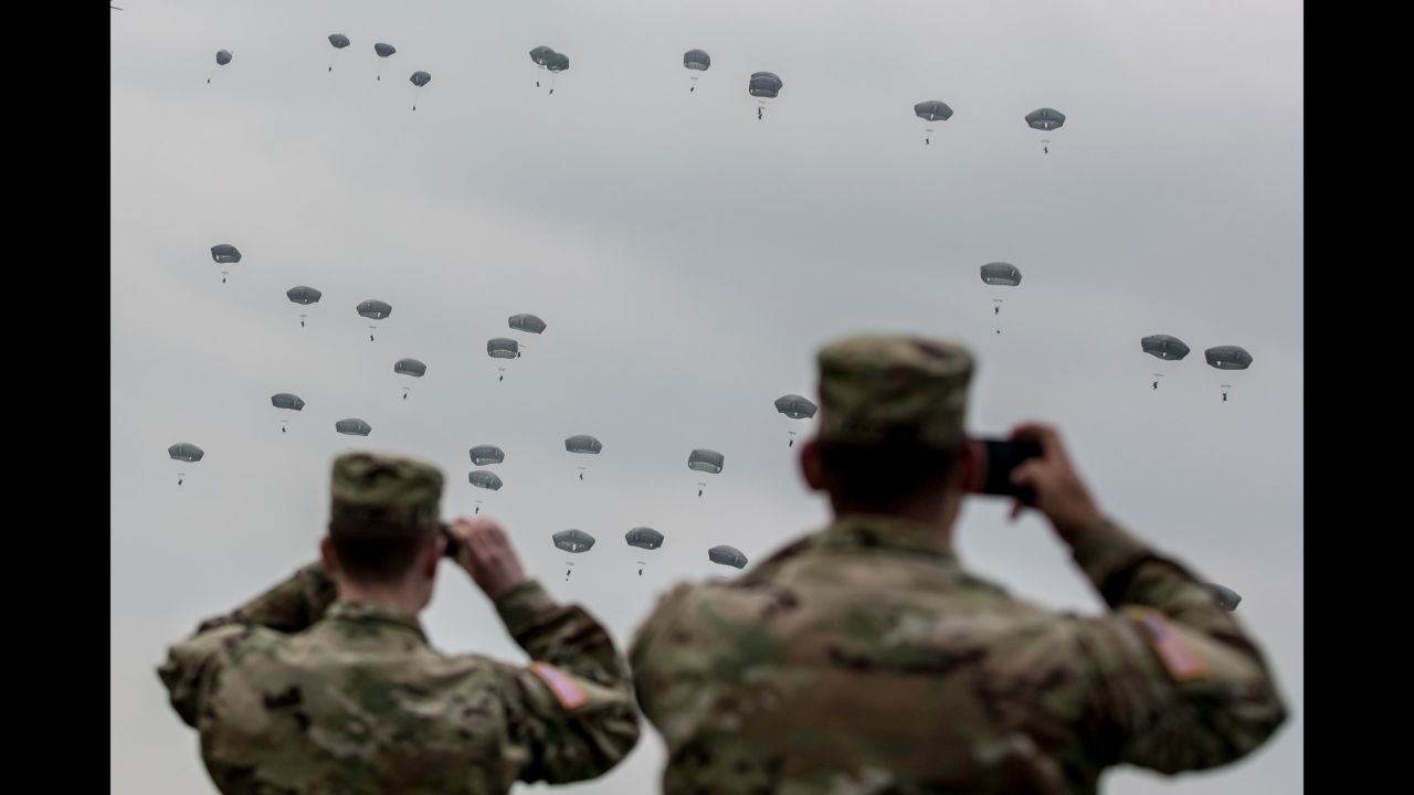 U.S. soldiers watch paratroopers take part in a training jump near Grafenwoehr, Germany, on Tuesday, April 12. The paratroopers were American, British and Italian.