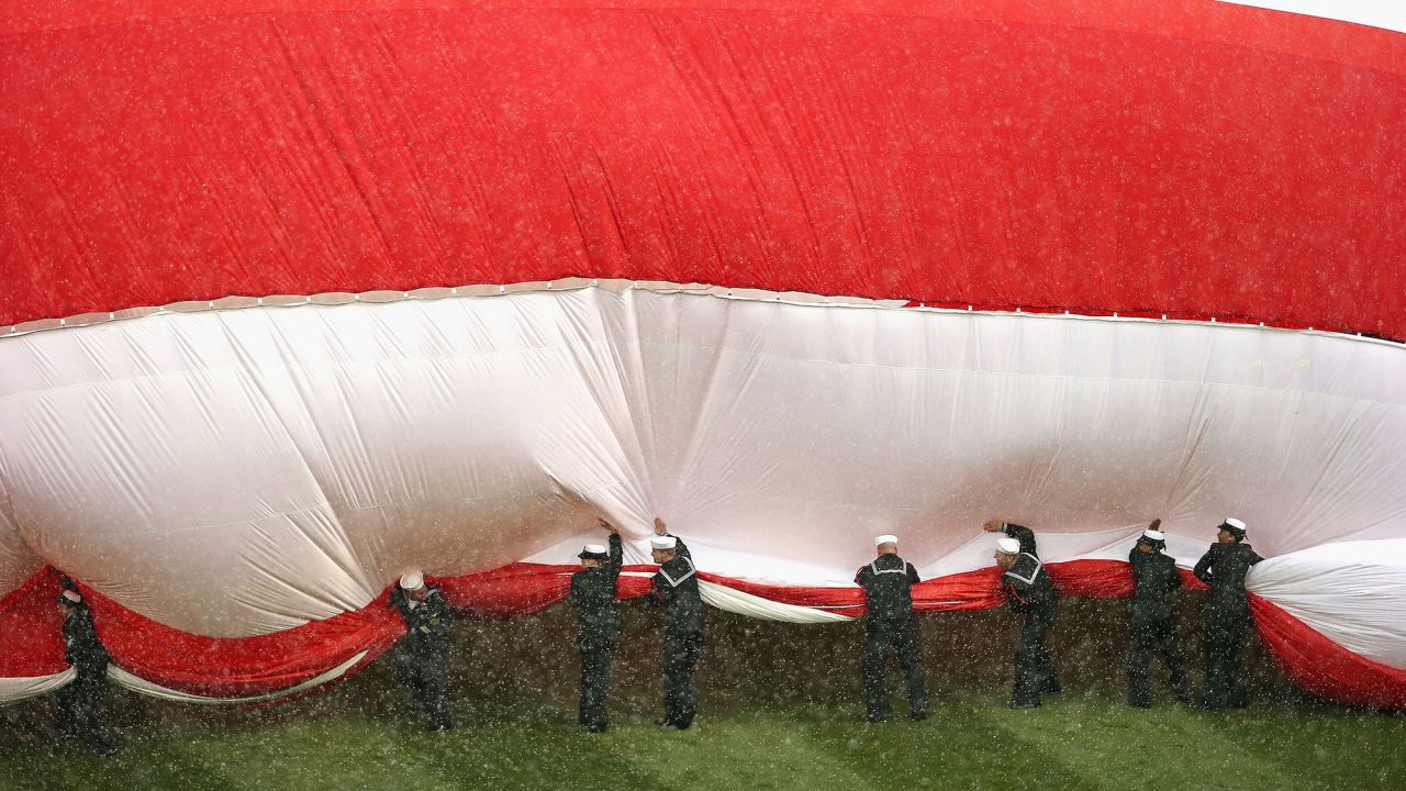 Sailors try to corral a large American flag before the home opener of the Chicago White Sox on Friday, April 8.