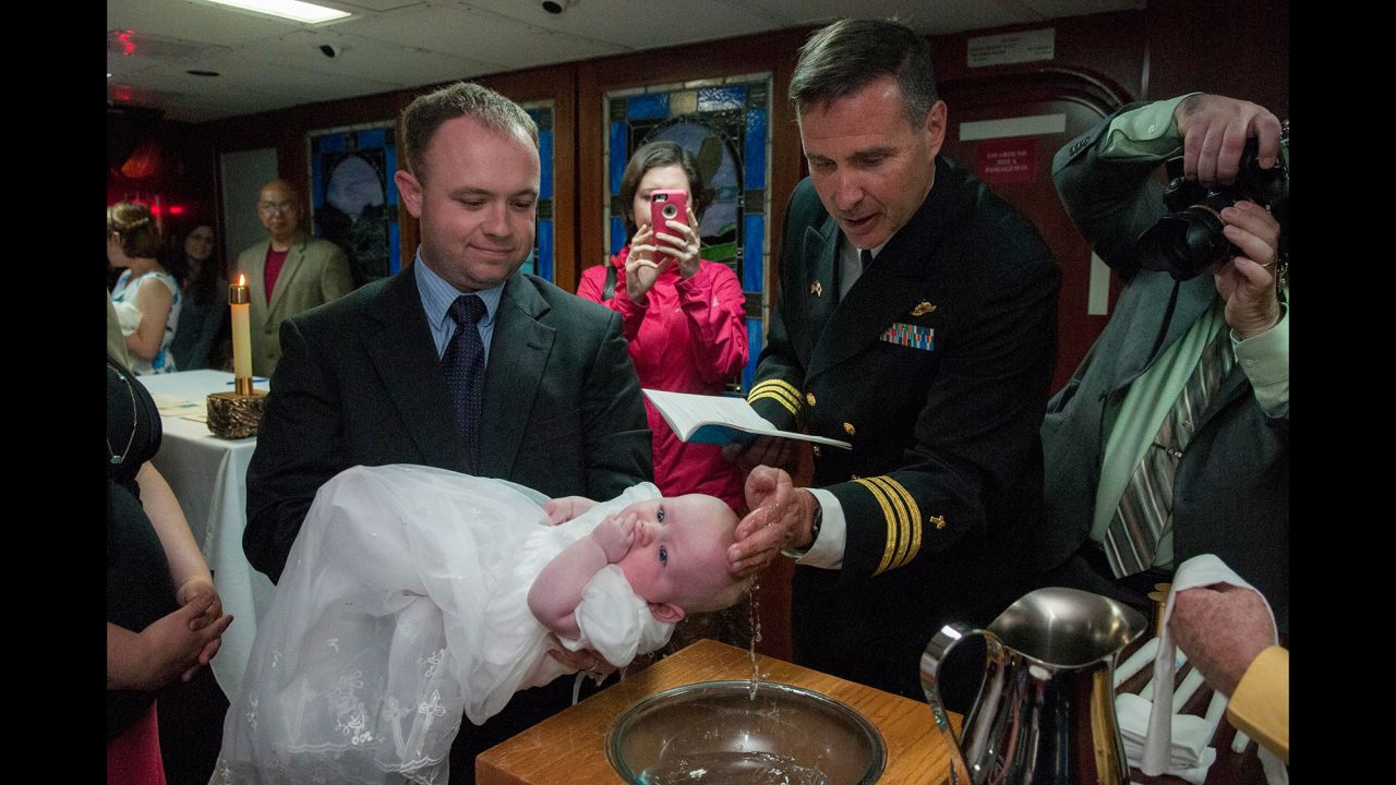 Cmdr. Joseph L. Coffey, a chaplain with the U.S. Navy, baptizes a child aboard the USS Ronald Reagan on Sunday, April 24. The aircraft carrier is docked in Yokosuka, Japan.