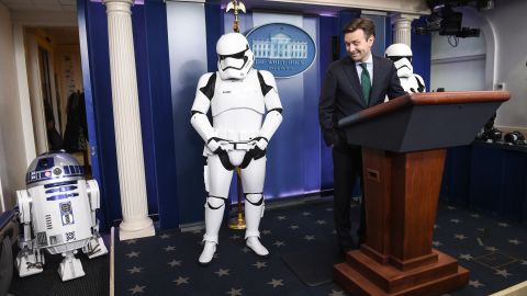 White House Press Secretary Josh Earnest speaks to the press in the briefing room at the White House in Washington, DC, on December 18, 2015 with Star Wars characters R2D2 and Storm Troopers.