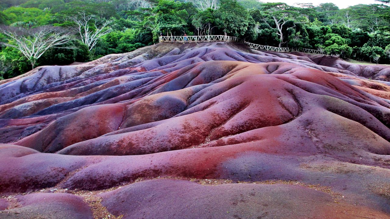 The colorful sand dunes in Charamel, Mauritius, are one of several places on Earth that resemble alien worlds. The striped sands are formed from volcanic rock but they remain a scientific mystery.