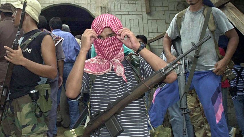 JOLO, PHILIPPINES:  (FILES) Dated 27 May 2000 file picture shows Al-Qaeda linked Abu Sayyaf gunmen guard a mosque in Bandang village, Jolo island where their leaders and group of negotiators meet for the release of 21 Asian and Western hostages.  Jolo, one of the Philippines southernmost islands boasts rich land and marine natural resources but serious peace and order problems have left the island mired in poverty. The Tausogs, the native Muslim tribes who make up the majority have  tradition for fierce martial courage and fondness for weaponry which has helped fuel the frequent explosions of violence in Jolo ranging from Muslim separatist wars, mass kidnapping campaigns, clan feuds and political disputes.   AFP PHOTO    ROMEO GACAD  (Photo credit should read ROMEO GACAD/AFP/Getty Images)