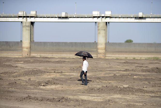 A man walks on the dry reservoir bed next to Gunda Dam in India's western Gujarat state on Friday, April 1.