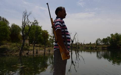 A gunman stands guard at a water reservoir in the central Indian state of Madhya Pradesh on Wednesday, April 27, 2016.