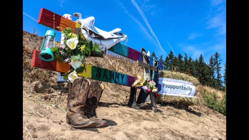 A memorial sits at the spot where Fuggetta and her horse were hit. On top of the post is a white saddle, and Sammy's bridle can be seen on the right. 