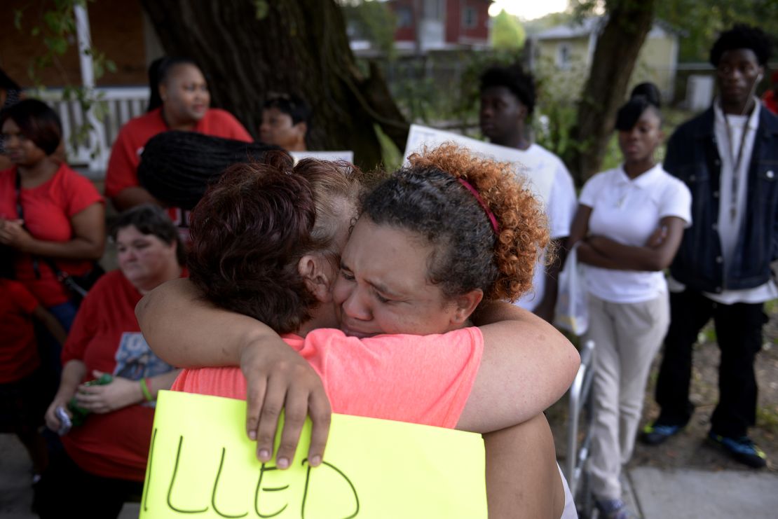 Martha Holmes, left, hugs Janie Smith, older sister of Charles Smith, who was shot and killed on Augusta Avenue by police in 2014.  