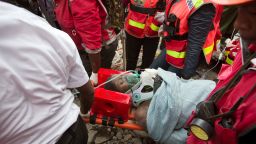 A woman is carried away on Thursday, May 5, in a stretcher by medics after she was pulled from the rubble of a collapsed building in Nariobi, Kenya. She was trapped in the rubble for six days.