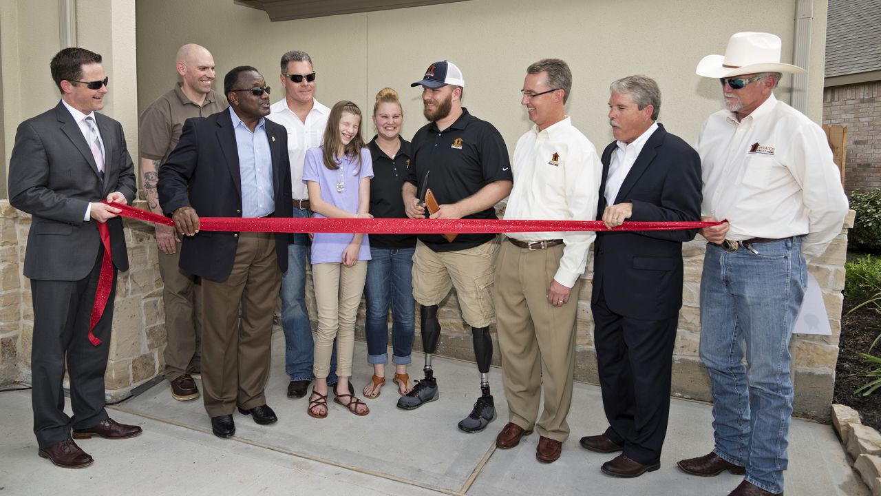 Cpl. Jonathan Dowdell (center) and his family cut the ribbon on a new home from Dan Wallrath (far right) and his nonprofit, Operation Finally Home.