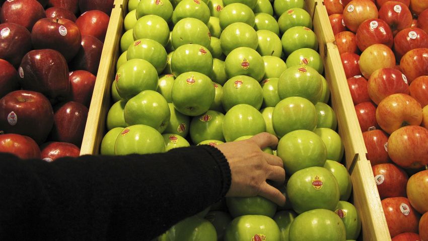 BEIJING - JANUARY 27:  A shopper chooses granny smith apples at the newly-opened Tesco supermarket on January 27, 2007 in Beijing, China. The UK giant opened its first own-brand supermarket in Beijing after investing in 46 stores across China under the name of its Chinese partner, Le Gou, which translates as "Happy Shopping". Tesco's new store in Beijing is competing with other international chains that are well established in China, such as Wal-Mart and Carrefour.  (Photo by Andrew Wong/Getty Images)