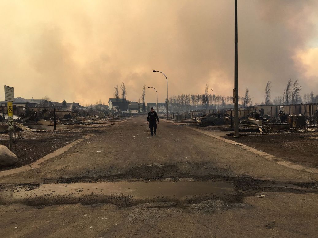 A member of the Royal Canadian Mounted Police surveys wildfire damage in Fort McMurray. The RCMP tweeted the photo on May 5.
