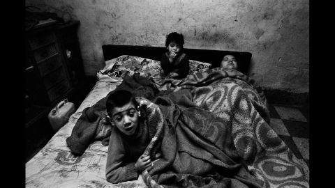 A woman and her children are photographed in Palermo in 1978. "I was shooting poor people, and I entered a house around noon," Battaglia said. "I asked her, 'Why are you in bed at this hour?' and she said, 'I have no fire, no light, no food ... what can I do?' People brought her spaghetti, but she was always in bed with the children. I always wondered what happened to this woman and those children."