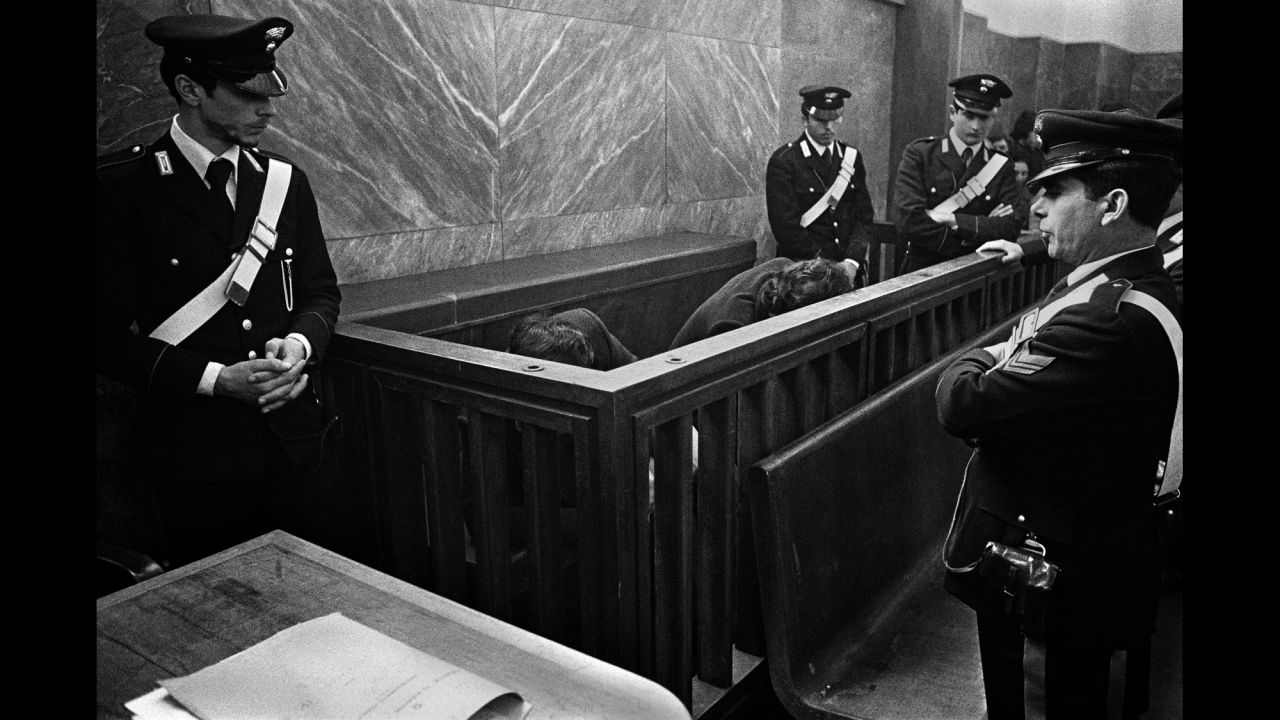 Men accused of organized crime hide from cameras at a trial in Milan, Italy, in 1971.
