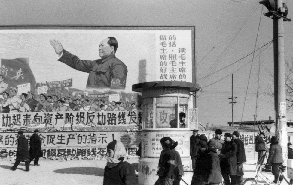 Beijing residents walk past a huge poster of Mao during the Cultural Revolution. The poster calls on people "to be good soldiers of Mao Zedong."