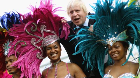 Johnson poses with members of a Carnival band in London on August 24, 2011.
