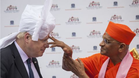 Spiritual leader Acharya Swamishree Maharaj marks a bindi on Johnson's forehead during a visit to a new Hindu temple in London on May 28, 2014.