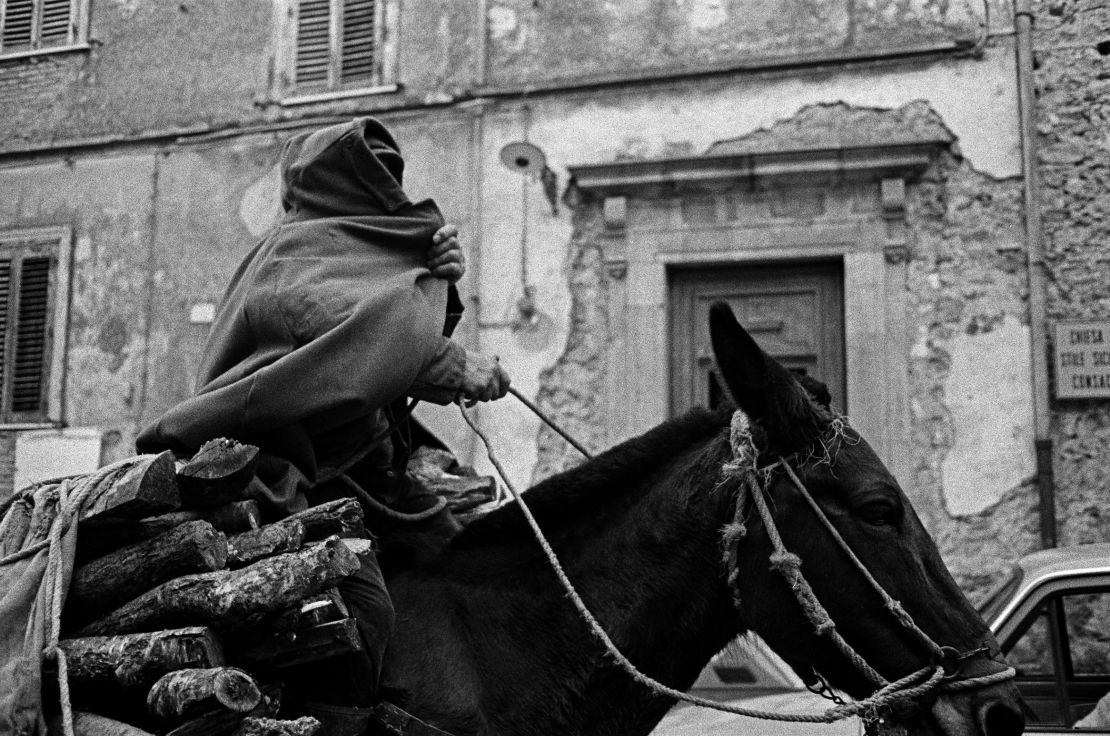 A man covers himself with a cloak in the streets of Sicily in 1989.