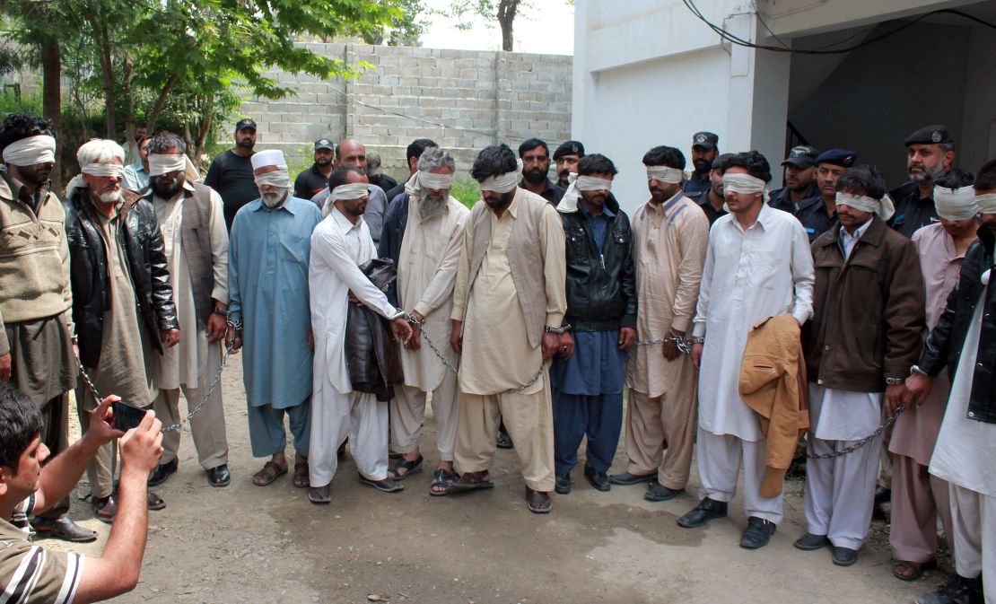 Police escort blindfolded suspects accused in the teen's killing to court Thursday in Abbottabad. 