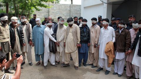 Police escort blindfolded suspects accused in the teen's killing to court Thursday in Abbottabad.