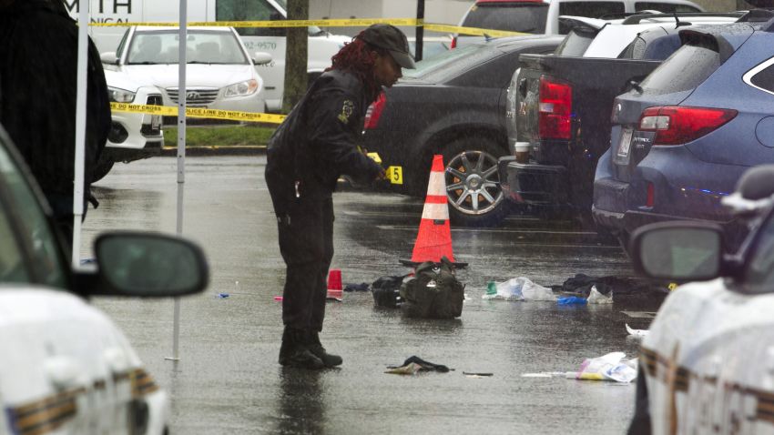 A Montgomery County, Md. Police officer marks evidence after a shooting outside Westfield Montgomery Mall parking lot in Bethesda, Md., Friday, May 6, 2016. Police in Maryland sat three people were hurt after the shooting. (AP Photo/Jose Luis Magana)