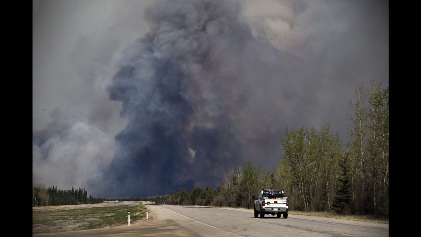 A truck drives toward a wildfire in Fort McMurray, Alberta, on Friday, May 6, 2016. More than 80,000 people have left Fort McMurray in the heart of Canada oil sands, where the fire has torched over 1,000 homes and other buildings. (Jason Franson /The Canadian Press via AP) MANDATORY CREDIT