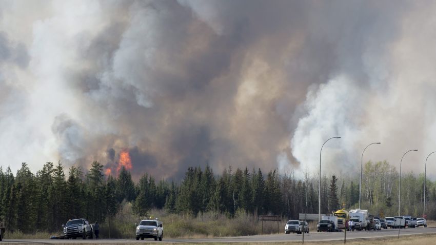 Wild fires burn south of Fort McMurray, Alberta, seen from highway 63 Friday, May 6, 2016. Displaced residents at oil field camps north of Fort McMurray, Alberta, got a sobering drive-by view of their burned out city Friday in a convoy that moved evacuees south amid a massive wildfire that officials fear could double in size by the end of Saturday. As police and military oversaw the procession of hundreds of vehicles, a mass airlift of evacuees also resumed.  (Jonathan Hayward/The Canadian Press via AP) MANDATORY CREDIT