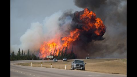 A ball of flame rises behind abandoned vehicles on Highway 63 near Fort McMurray on Saturday, May 7.